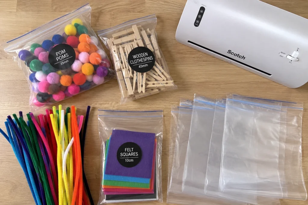supplies for making busy bags for toddlers including pom-poms clothespins and pouches