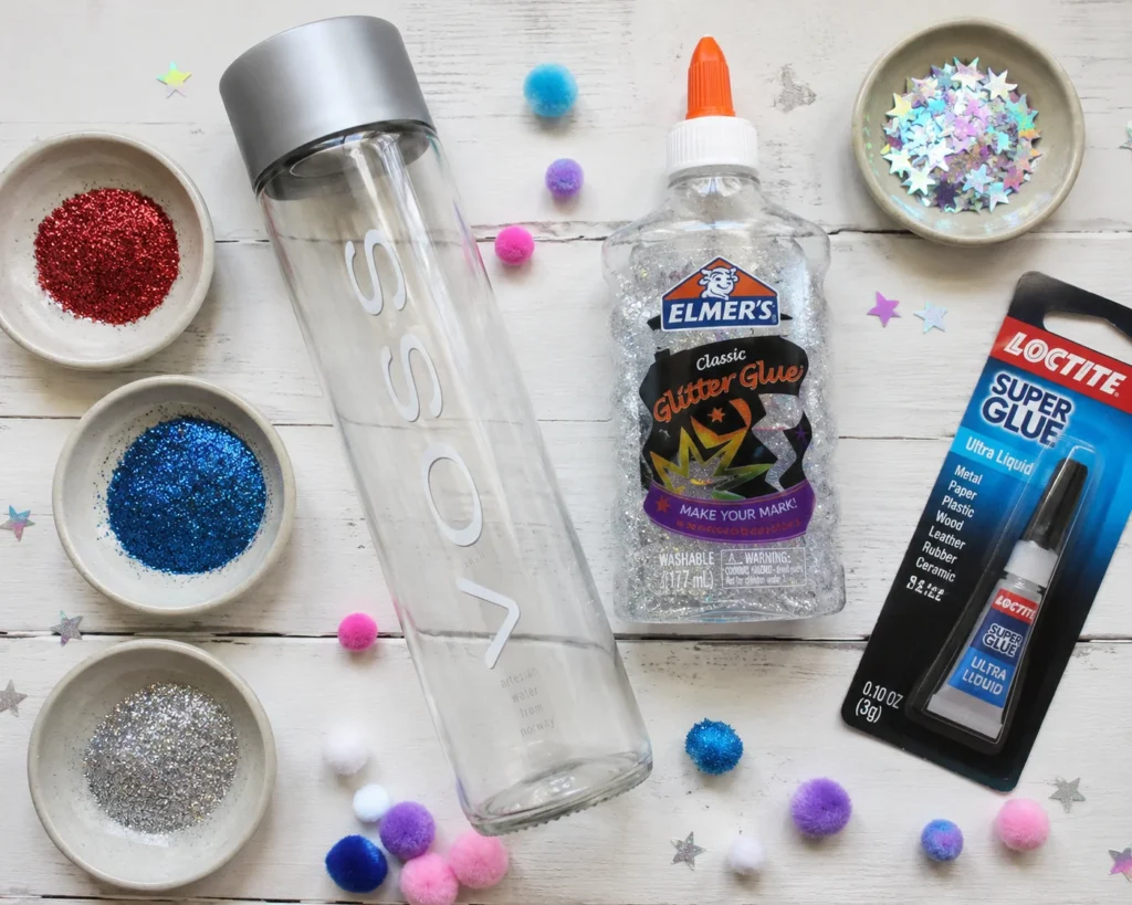 Supplies for making DIY sensory bottles: clear bottle, glitter glue, glitter, and star confetti